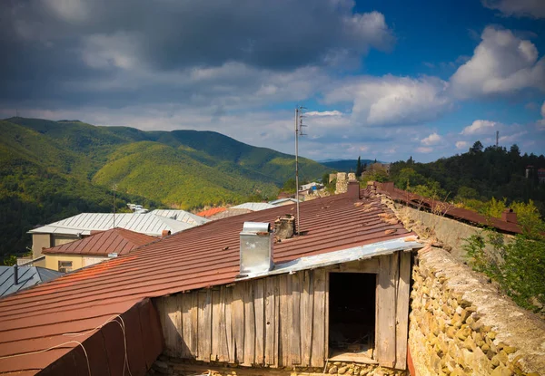 Telhado da velha casa de madeira no fundo da bela montagem de outono — Fotografia de Stock