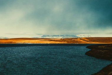 İzlanda'nın taşlık kayalık ıssız manzara parlak mavi göl. T
