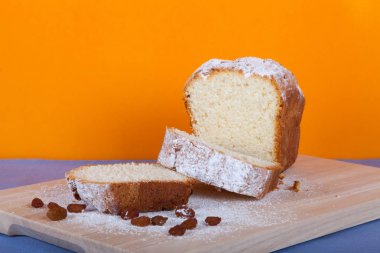 Ahşap kesme domuzu üzerine pudra şekeri ile lor pasta dilimleri