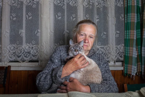 Mulher idosa com gato no interior rústico — Fotografia de Stock