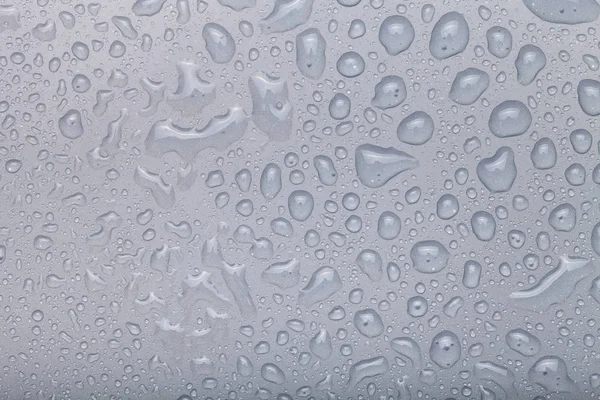 Gotas de água em um fundo a cores. Cinza — Fotografia de Stock