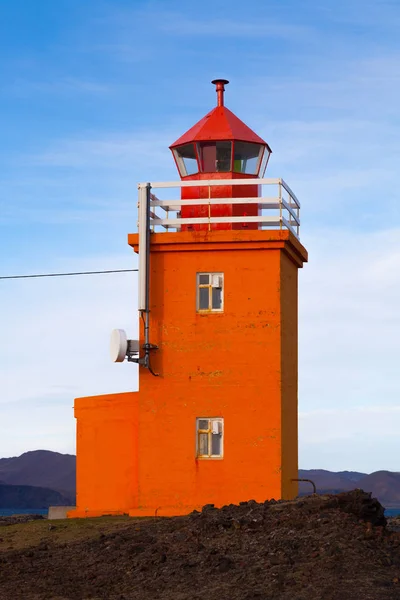 Faro arancione su una costa pietrosa in Islanda — Foto Stock