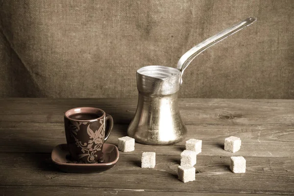 Cup of cofee, tirk and sugar on old wooden table opposite sackcl — Stock Photo, Image