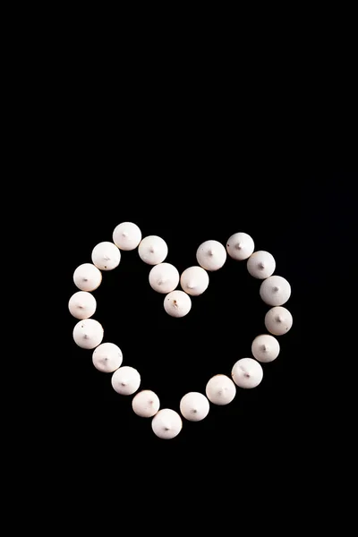 Small cookies laid in the shape of heart on black background — Stock Photo, Image