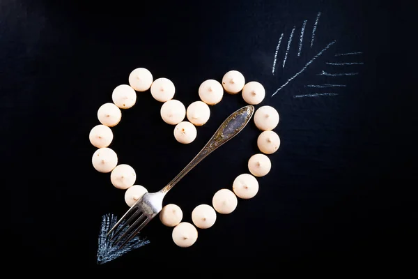 Pequenos biscoitos em forma de coração com flecha e garfo em — Fotografia de Stock
