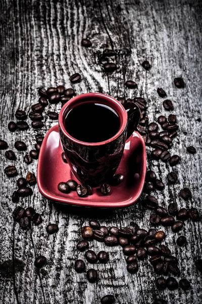 Чашка кофе и кофейных зерен на старом сером деревянном столе. Выборочный подход — стоковое фото