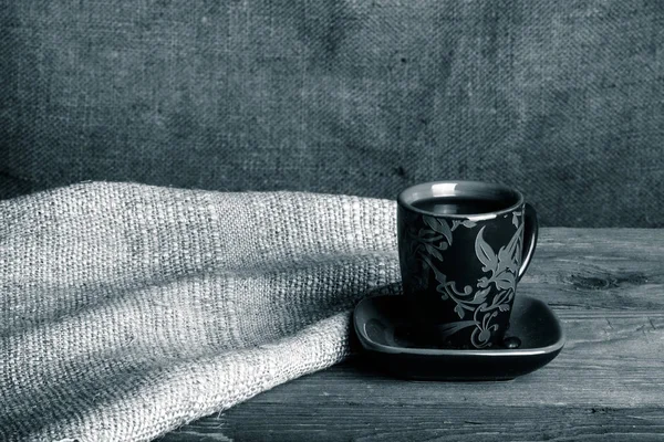 Cup of cofee on old wooden table opposite sackcloth background. — Stock Photo, Image