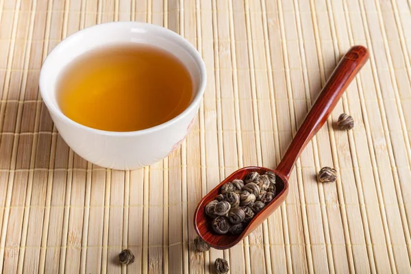 Зеленый чай на светлом бамбуковом коврике — стоковое фото