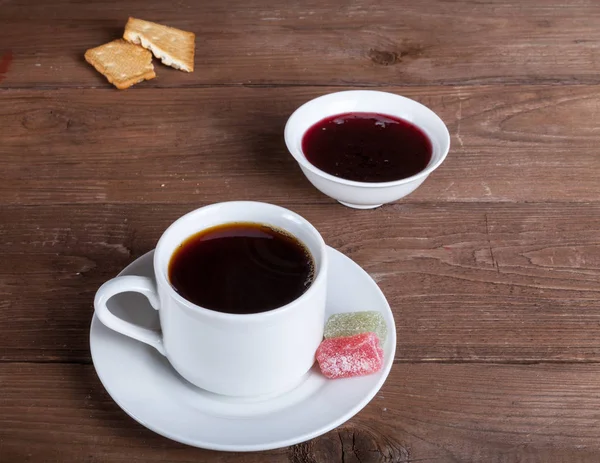 Cup of tea with jam, biscuits and marmalade on old wooden table — Stock Photo, Image