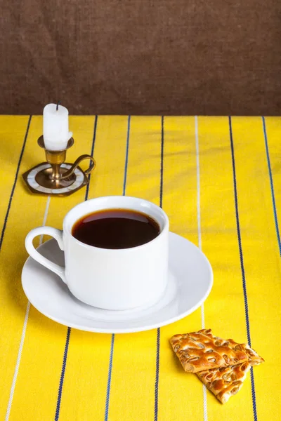 Tasse de thé avec biscuits et bougie de style rétro sur le y rayé — Photo