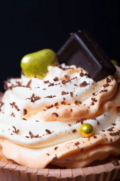 Vanille-Cupcakes mit orangefarbenem und weißem Frischkäse und Schokolade — Stockfoto