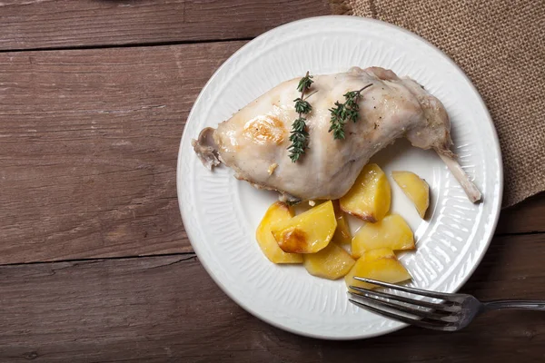 Prerared rabbit meat with potato on a rustic style background — Stock Photo, Image