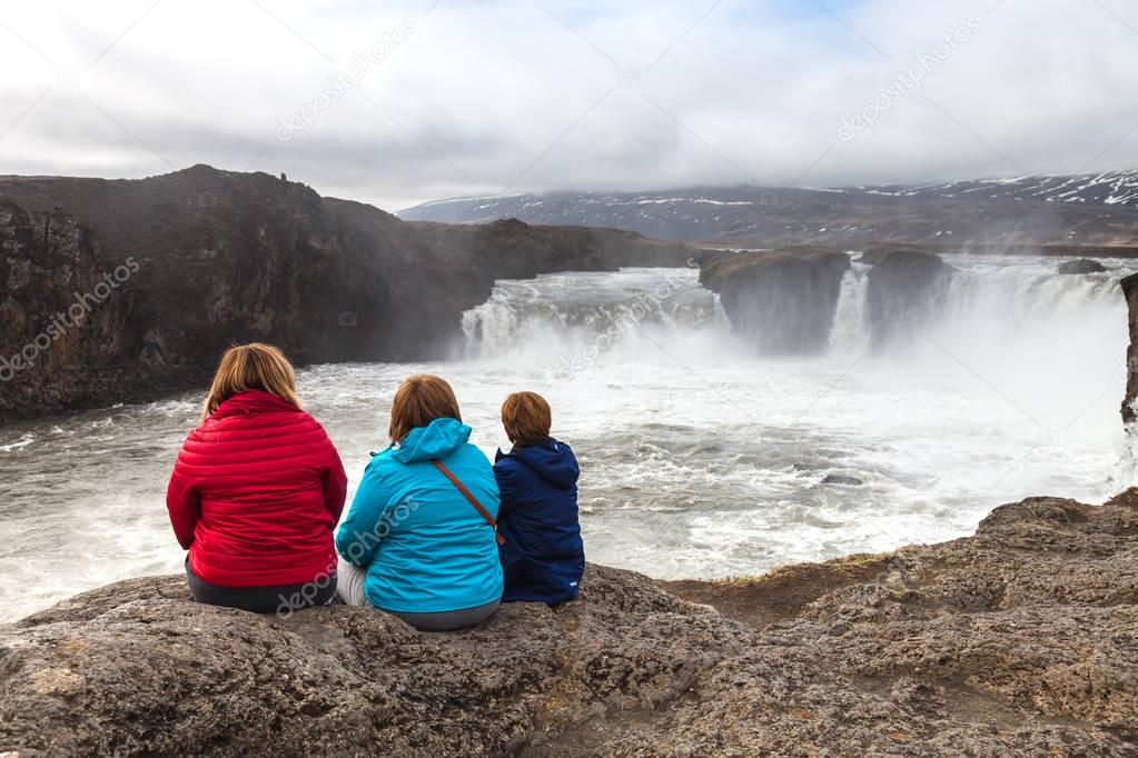 Three women looks on the Godafoss Waterfall - beautiful part of 