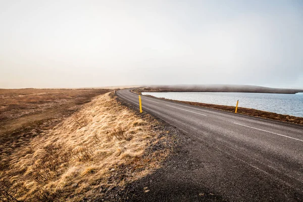 Asphalt road on the shore of the fjord in the east of Iceland. T — Stock Photo, Image