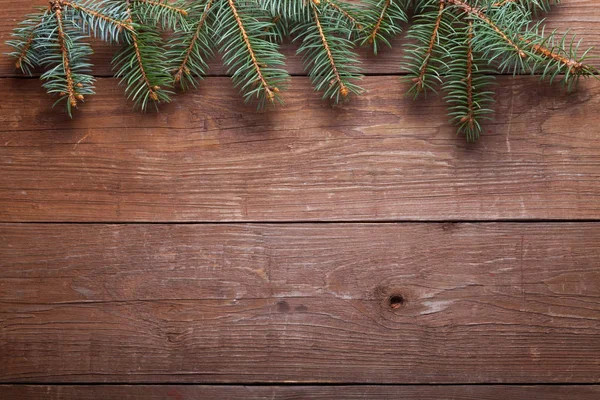 나무 테이블이 나 배경에 대 한 보드에 크리스마스 트리 분기. — 스톡 사진