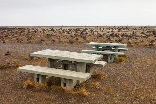 アイスランドの石の岩が多い砂漠の風景に古い木製のベンチ — ストック写真