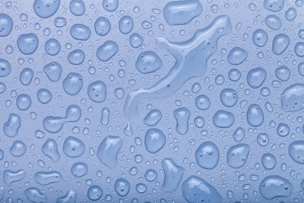 Gocce d'acqua su uno sfondo a colori. Blu. Concentrazione selettiva. Tonnellata — Foto Stock