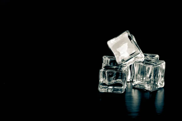Ice cubes on black background. Selective focus. Toned — Stock fotografie