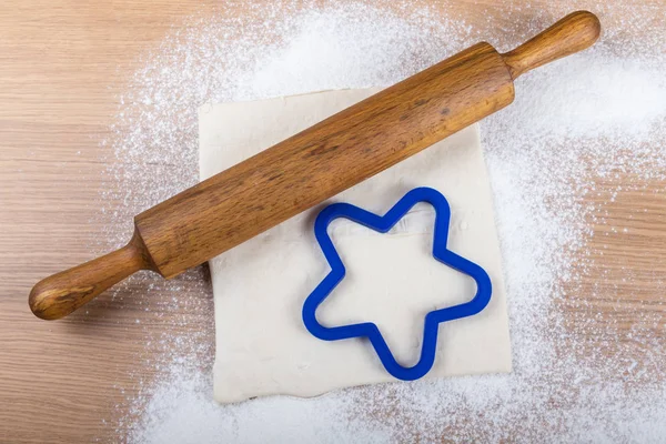 Set for home baking on a light wooden table with flour. Rolling