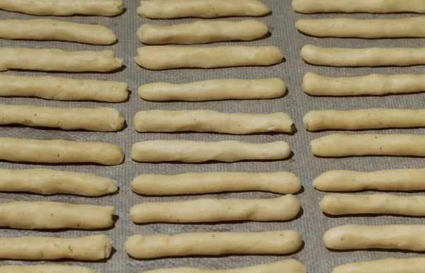 Fresh unbaked cheese sticks on a baking paper for background — Stock Photo, Image