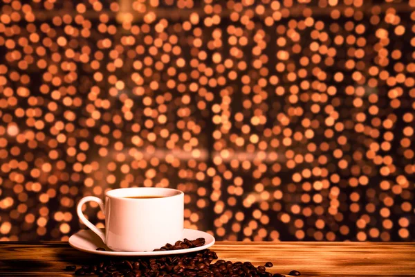 Kawa w filiżance na drewnianym stole naprzeciwko niewyraźnym tłem — Zdjęcie stockowe