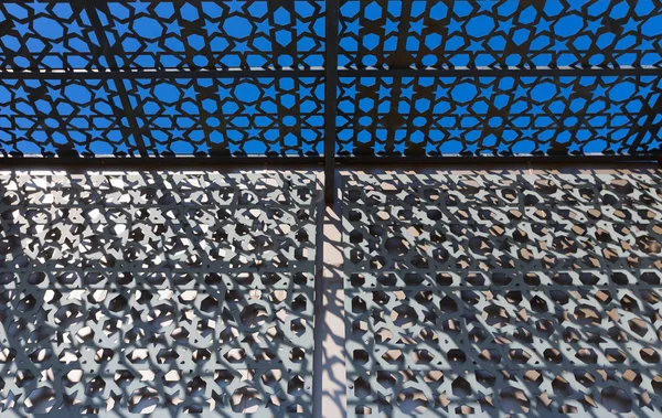 Schéma géométrique abstrait du soleil à travers un treillis métallique — Photo