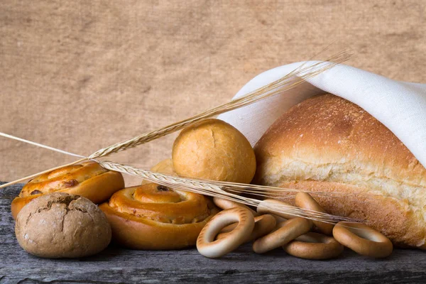 Taze ekmek ve buğday farklı eski ahşap ta tırmanıştır — Stok fotoğraf