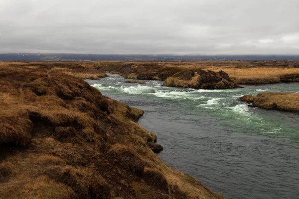 Rivier en verdoofd gras op een dramatisch landschap van IJsland — Stockfoto