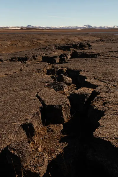 Cracks on a dry earth on a calm deserted spring landscape of Ice — ストック写真
