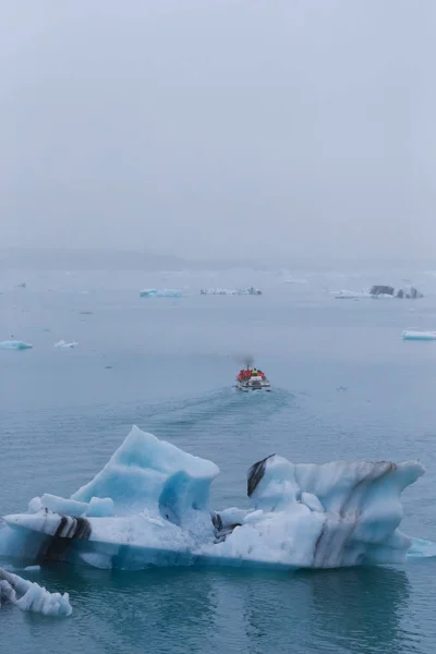 Muž na lodi mezi bizarními ledovými kry Ledové laguny vtipy — Stock fotografie