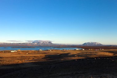 İzlanda 'daki küçük kasabaya ve karlı dağlara bakın. Ayarlanmış