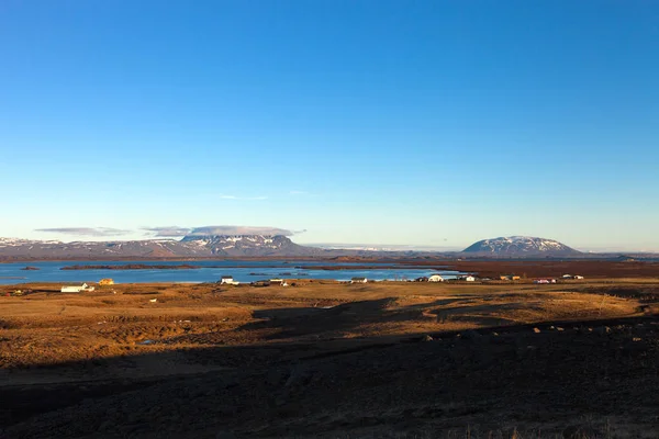 Utsikt över den lilla staden och snöiga bergen på Island. Tonad — Stockfoto