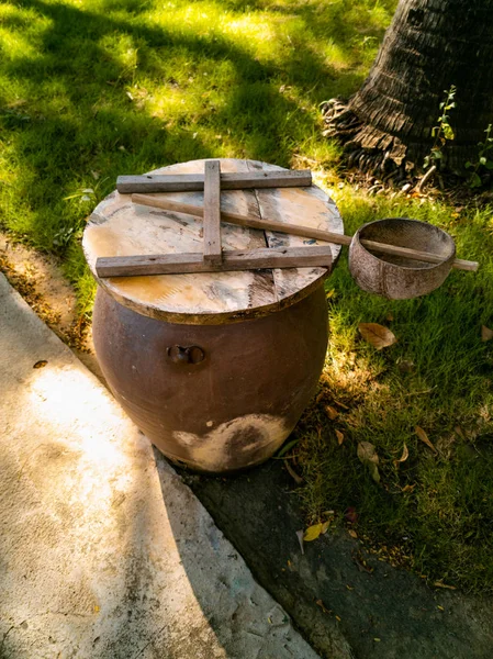 Clay barrel and coconut half ladle near hut on a territory of ho — Stock Photo, Image