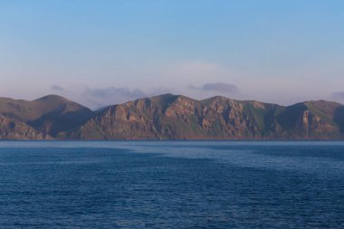 Denizden Tyatya volkanı ile Kunashir adasını seyret.
