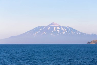 Denizden Tyatya volkanı ile Kunashir adasını seyret.