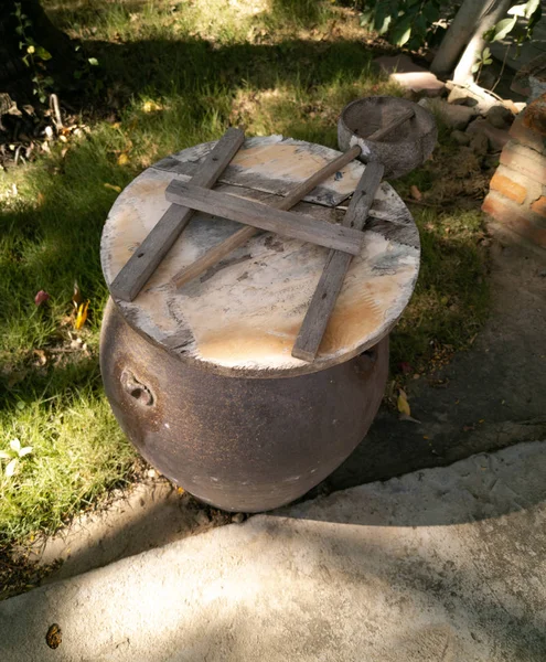 Clay barrel and coconut half ladle near hut on a territory of ho — Stock Photo, Image