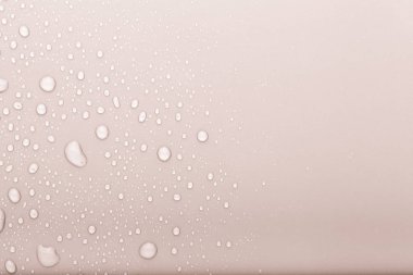 Renkli arka planda bir damla su. Seçici odaklanma. Bej rengi. Buraya...