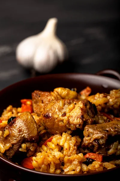 Gran porción de pilaf en un plato de barro. Delicioso uzbek casero —  Fotos de Stock