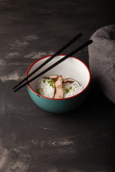 Koostumus kulhoon riisin nuudeleita, lihaa ja vihanneksia — kuvapankkivalokuva