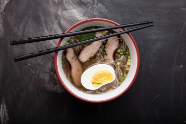 Bir kase pirinç eriştesi, et ve sebzeli kompozisyon.