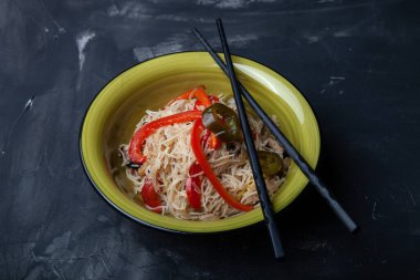 Bir kase pirinç eriştesi, et ve sebzeli kompozisyon.