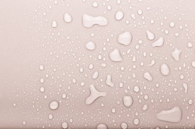 Renkli arka planda bir damla su. Seçici odaklanma. Bej rengi. Ayarlanmış.