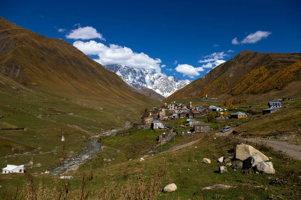 Köy, Ushguli güzel bir sonbahar manzara içinde Svaneti beyaz bulutlar ile görünümünü. Gürcistan.