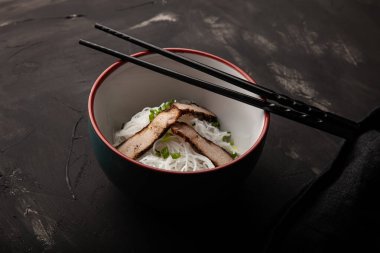 Bir kase pirinç eriştesi, et ve sebzeli kompozisyon..