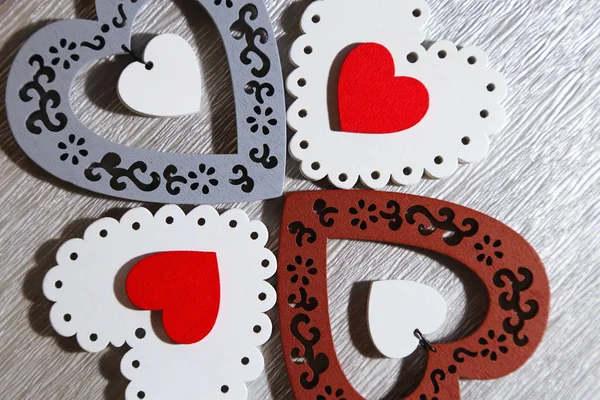 Valentinstag, Hochzeit, Liebe. weißes Tracery, rot, grau, braun, helle Holzherzen auf silbergrauem Hintergrund für Glückwünsche oder Einladungen. — Stockfoto