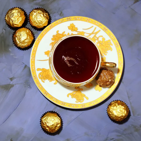Teetrinken. Porzellantasse mit Tee und Dessertschokolade. — Stockfoto