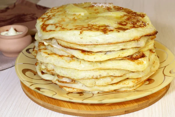 Food. Appetizing baked thick yeast pancakes are stacked on a plate on the table. — Stock Photo, Image