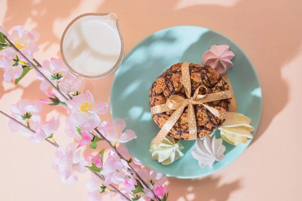 Frisch gebackene Haferflocken knusprige Kekse auf einem blauen Teller auf einem Hintergrund von Pfirsichfarbe, Milch, Französisch mehrfarbigen Baiser. leckeres kulinarisches Dessert, romantisches Festfrühstück, Essen, Snacks — Stockfoto