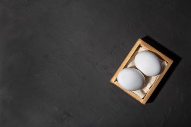 Beyaz tavuk yumurtaları, fotokopi alanı olan siyah arka plan. Vitamin, protein, amino asit, kolesterol, kalsiyum, potasyum, fosfor, magnezyum, iyot içeren gıda ve ürünler