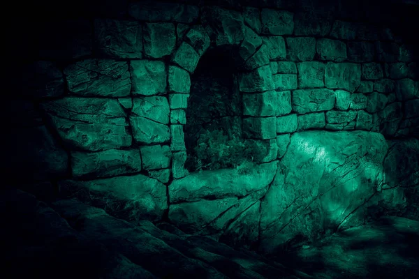 The corridor is horror, scary, darkness. Ghostly gloomy cave in the castle, alcove in the tunnel, entrance to the basement in the mystical night light of the moon with terrible strange green shadows